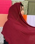 شال کریشه تابستونی با رنگ زرشکی عمیق، دارای بافت ریز راه‌دار و لبه‌های ریش‌ریش، سبک و مناسب برای استایل‌های شیک و تابستانی