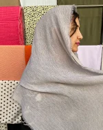 شال کریشه تابستونی با رنگ طوسی نقره‌ای روشن، دارای بافت ظریف و راه‌دار با لبه‌های ریش‌ریش، سبک و خنک برای استفاده روزمره در فصل تابستان