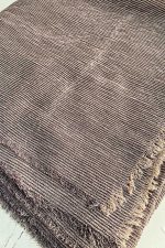تصویر نمای نزدیک از بافت شال کریشه تابستونی با رنگ قهوه‌ای تاپی، دارای بافت ریز راه‌دار و لبه‌های ریش‌ریش، مناسب فصل تابستان