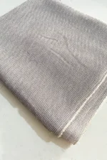 عکس از شال نخی طوسی روشن بدون چین با بافت ظریف و لطیف، تا شده روی سطح سفید در نور طبیعی.