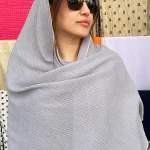 شال نخی طوسی روشن ساده با بافت ظریف، مناسب استایل روزمره و رسمی، تصویر گرفته‌شده روی سر مدل در نور طبیعی.
