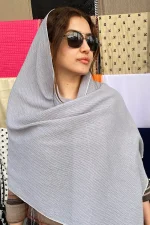 شال نخی طوسی روشن ساده با بافت ظریف، مناسب استایل روزمره و رسمی، تصویر گرفته‌شده روی سر مدل در نور طبیعی.
