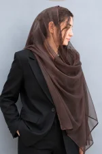 شال توری قهوه‌ای زنانه روی سر مدل همراه با کت مشکی، مناسب استایل رسمی، خاص و مجلسی